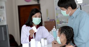 asian female pharmacist wearing face mask talk about detail drug vitamin and antiviral with customers in the pharmacy store Thailand footage video 4k, health care concept,