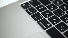 Hand pressing option key on modern laptop keyboard close-up slow motion 