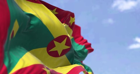 Detail of the national flag of Grenada waving in the wind on a clear day. Grenada is an island country in the West Indies in the Caribbean Sea. Selective focus. Seamless loop in slow motion