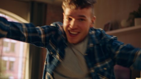 Portrait of Handsome Young Male Dancing in Cozy Home Clothes, Having a Party for Himself in Loft Apartment. Recording Funny Viral Videos for Social Media. Close Up Handheld Shot.