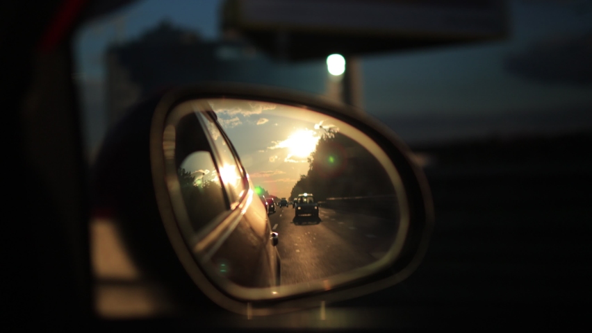 View in the side rear view mirror of a car driving a red car on a highway Royalty-Free Stock Footage #1088006897