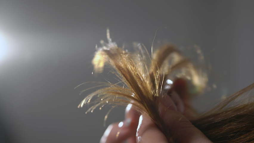 Young woman brushes her hair with comb. Beautiful girl is going in front of a mirror. Female is doing and styling her hair. Caucasian person at home in the morning. Split ends, unhealthy broken hair. | Shutterstock HD Video #1088008309