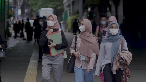 Jakarta, Indonesia-March 06, 2022: Slow motion Train passengers wearing protective masks walk out of Central Jakarta's Dukuh Atas train station.