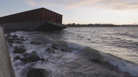 Barge container ship collided on a rocky coast during wind storm. Sunset Sky. Seawall, Downtown Vancouver, British Columbia, Canada. Slow Motion