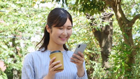 Asian woman  using the smartphone in fresh green