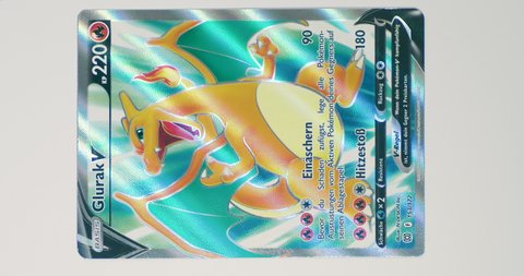 Hamburg, Germany - 03 08 2022: video of the German ultra rare card Charizard V BRS 153 from the set brilliant stars. led light is moving over pokemon trading card to show the holo rainbow paper surface.