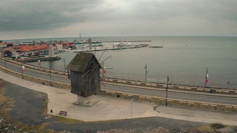 Aerial drone fly over windmill in old town Nessebar Bulgaria. Beautiful Landscape view of small town into the Black Sea at winter cloudy contidions.