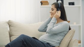 4k video of pregnant woman listening to music.