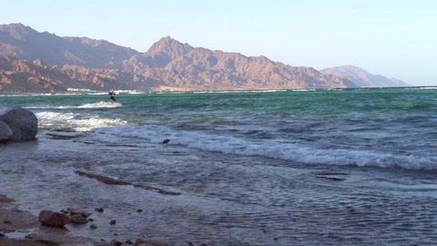 Waves hitting the beach in dahab sinai egypt with a kitesurfer 4k