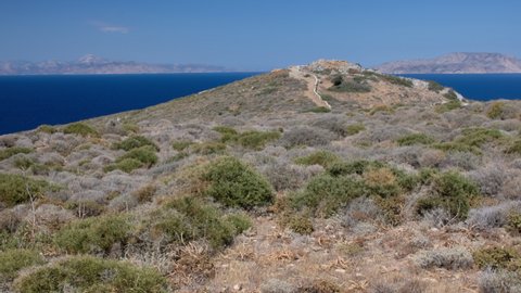 View of the Tomb of the famous Greek poet Homer from a distance,  and the Aegean Sea in the background in Ios Greece 