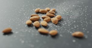 Video of almonds on grey background. fresh vegan food, plant based diet, healthy eating concept.