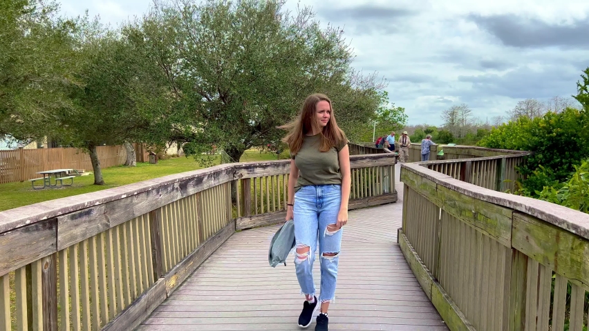 Young woman walks across a jetty in the Everglades - travel photography