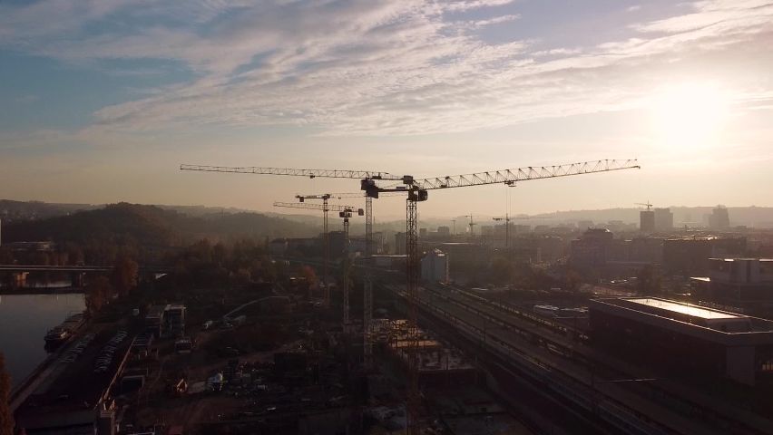 Aerial flight over a constructions site with high tower construction cranes building real estate. . Construction of a residential area in a city. | Shutterstock HD Video #1088028339