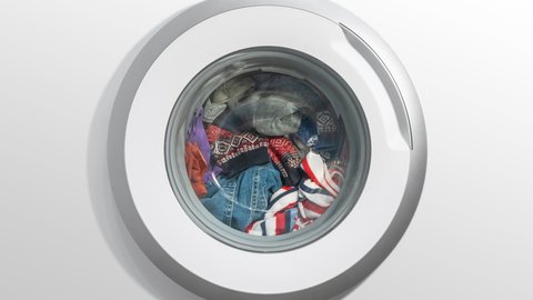 Timelapse white domestic washing machine, laundry machine wash colored clothes time-lapse shot. Washing clothes. Motion blur round drum, spinning circle on white background