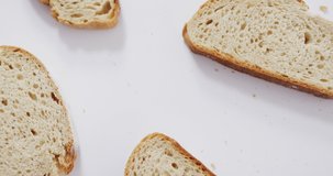Video of slices of bread seeing from above on white background. food and cooking ingredients concept.