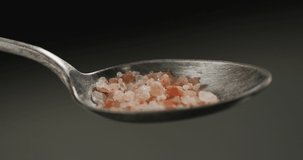 Video of cook throwing salt on the table on black background. food and cooking ingredients concept.