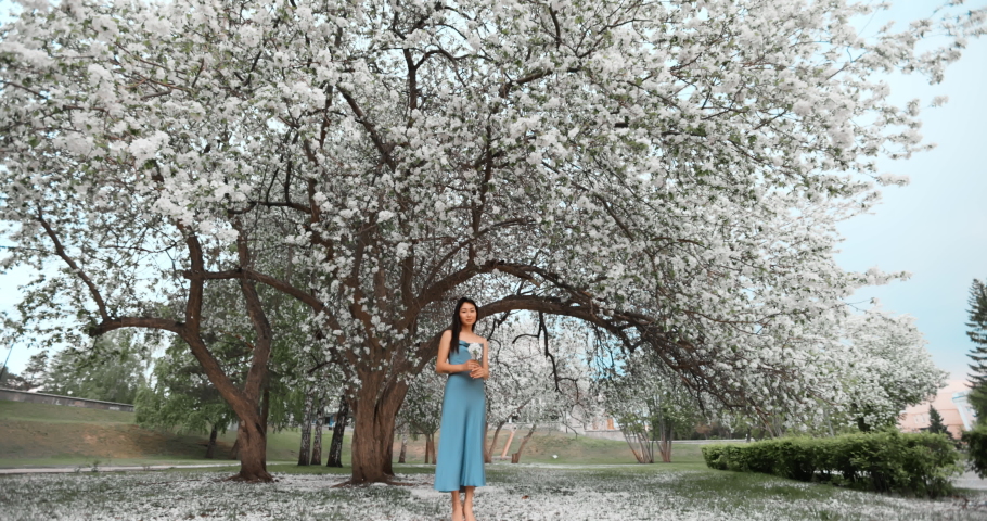 Woman in blooming apple trees