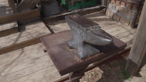 This panning video shows an old antique anvil at a blacksmith outdoor workshop.