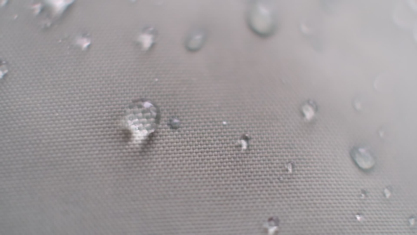 Slow Motion Shot of Water Splashing on waterproof fabric. water beading on fabric. Waterproof coating background with water drops. soft focus, blur Royalty-Free Stock Footage #1088034993