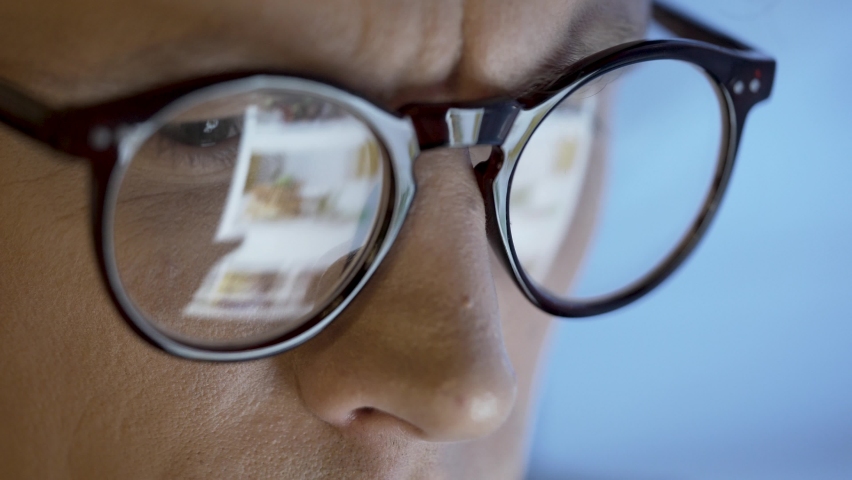 Social Media Addict Scrolling Feed. This is close up shot of man’s face looking at smart device and reading social information stream online. We can see feed screen reflections on his glasses. | Shutterstock HD Video #1088035337