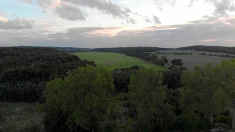 drone aerial close flight over treetops with wide view over fields