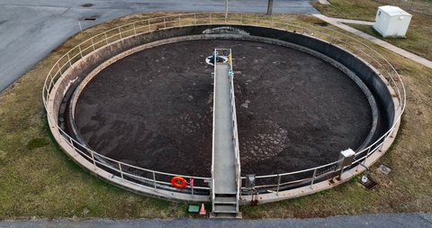 Round holding tank at municipal sewer treatment facility plant. Stinky brown wastewater was human feces from local sewerage. Water purification process.