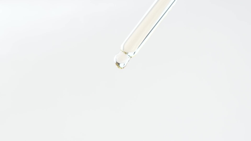 Glass dropper with cosmetic liquid on a plain background close-up. Royalty-Free Stock Footage #1088042753