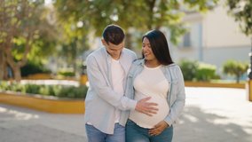 Young latin couple smiling confident touching belly walking at park - Powered by Shutterstock - Get 15% off with code: PIKWIZARD15