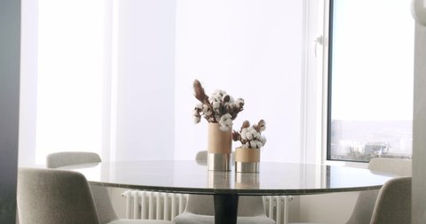 Minimalist Modern White Dining Room with white chairs and minimalist lamp. Minimalist Dining Table. luxury kitchen in modern style, Modern House. Minimalist Design Interior. Estate cozy dining room.