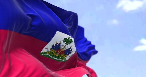 Detail of the national flag of Haiti waving in the wind on a clear day. Haiti is a country located on the island of Hispaniola in the Greater Antilles. Selective focus. Seamless looping in slow motion