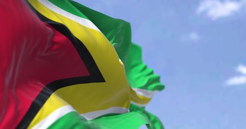 Detail of the national flag of Guyana waving in the wind on a clear day. Guyana is a country on the northern mainland of South America. Selective focus. Seamless looping in slow motion
