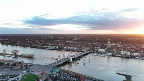Kampen city skyline aerial view from the river IJssel with the sunset in the distance during a cold winter evening.