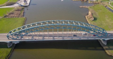 Decending 4k Aerial drone shot of The Old IJsselbrug over the river IJssel between Zwolle and Hattem with a Jetsky passing underneath.