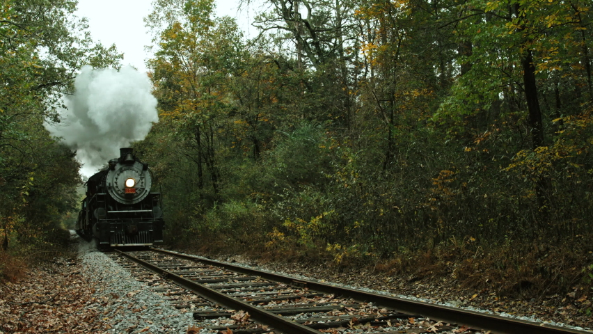 Old and antique steam locomotive passing by the railroad tracks, vintage passenger train, still shot Royalty-Free Stock Footage #1088056481