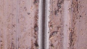 Drone shot looking down on railroad tracks in the center of the video frame