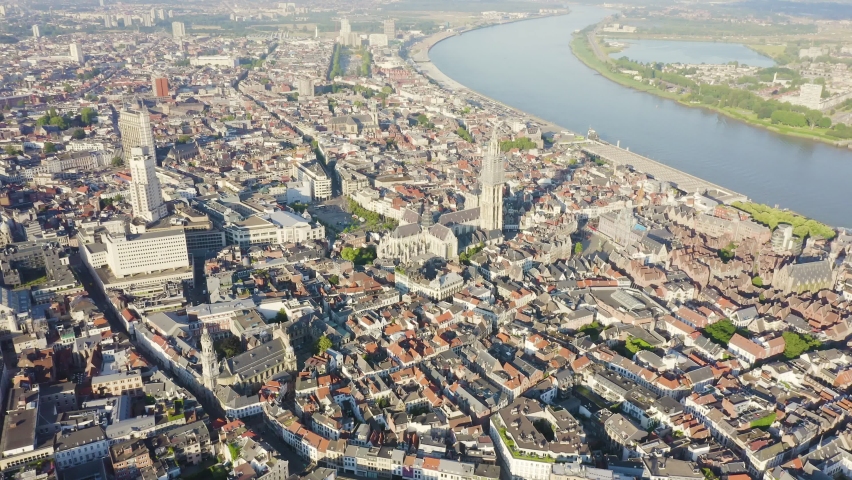 Inscription on video. Antwerp, Belgium. Flying over the roofs of the historic city. Schelde (Esco) river. Cathedral of Our Lady of Antwerp. (Onze-Lieve-Vrouwekathedraal Antwerpen). Glitch effect text