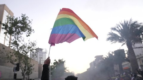 SANTIAGO, CHILE - October 18, 2021 Protesters raise the LGTBi flag on October 18, the anniversary of the social outbreak in Plaza Baquedano