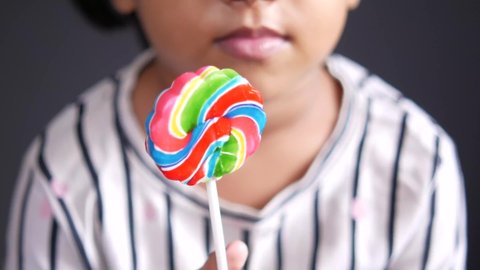 child girl holding a lollipop candy 