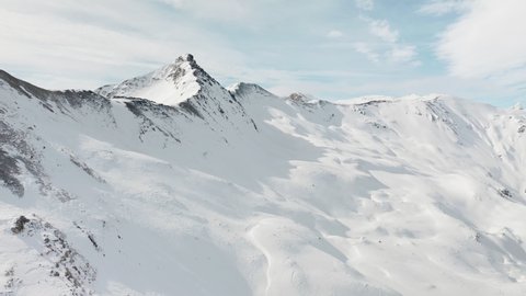 4k aerial footage of panoramic view of snowy mountains at alpine ski resort in Livigno, Italy. Snow mountain range landscape on winter sunny day. Beautiful panorama of European Alps video from drone