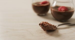 Video of chocolate pudding with strawberries and bluberries on a wooden surface. party food and savoury snacks.