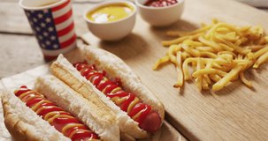 Video of hot dogs with mustard, ketchup and chips on a wooden surface. food, cuisine and catering ingredients.