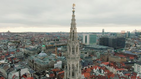 Gothic Tower of Brussels Flamboyant Town Hall with statue of Saint Michael. Aerial View of the Grand Place in Bruxelles, Belgium. Tourist destination and famous European landmark. 4K drone orbit shot