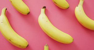 Video of fresh bananas on pink background. fusion food, fresh fruit and healthy eating concept.