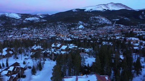 Aerial drone footage over homes in the valley in Breckenridge, Colorado, United States at sunset. Coniferous forest. Winter landscape.