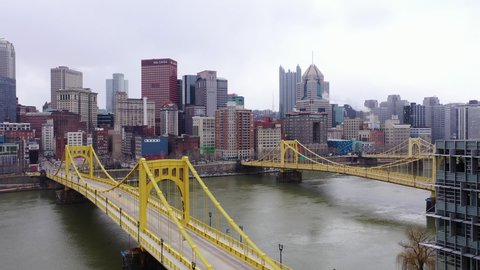 Pittsburgh , United States - 03 04 2022: Drone pan shot of downtown Pittsburgh looking across the Monongahela River with the Roberto Clemente Bridge in the foreground.