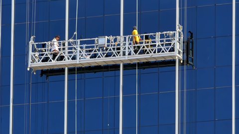 Cebu City , Philippines - 03 02 2022: Cebu City, Philippines -- 02 March 2022: Workers perform maintenance work on the exterior glass wall of a high-rise commercial building in this city.