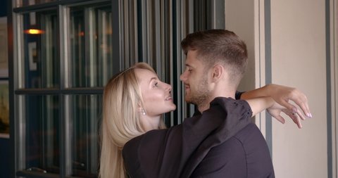 Beautiful people man and woman hugging at restaurant