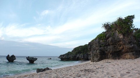 KOURI ISLAND, NAKIJIN, OKINAWA, JAPAN - AUG 2021 : View of Thinu-hama beach (Ocean or sea) and heart rock in sunset time. Summer holiday, vacation and resort concept video.