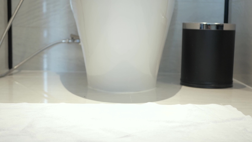 a man while using sitting on the toilet with relaxtion