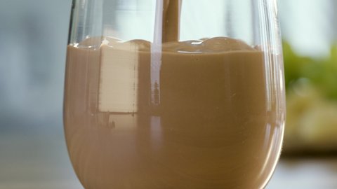 Close up pouring chocolate milk into a glass